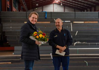 Männer in Lager vor Stahl mit Blumen