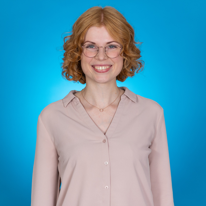 Frau mit roten Haaren vor blauer Wand